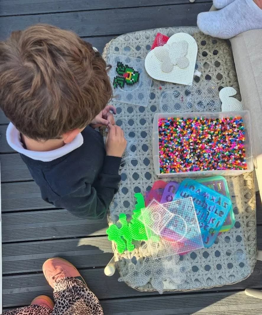 A child working on a beadwork pattern in our garden