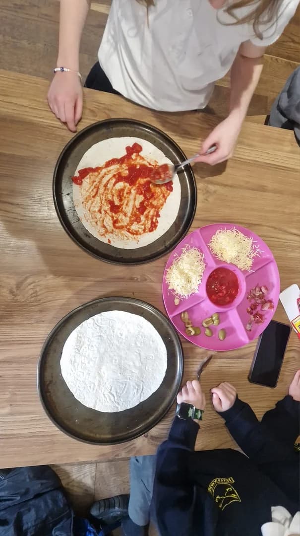 Children making homemade pizzas at the table