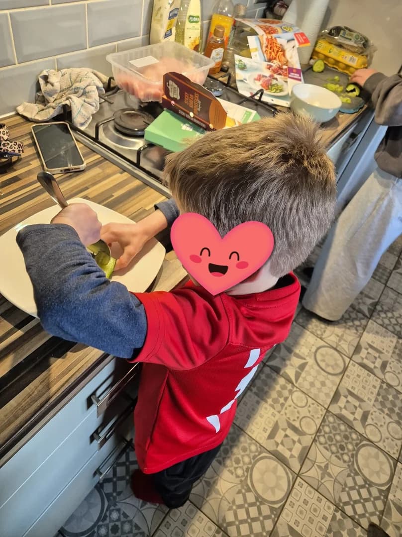 A child helping wash the dishes after a baking afternoon