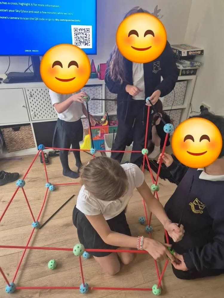 Children building with magnetic construction sticks in the playroom