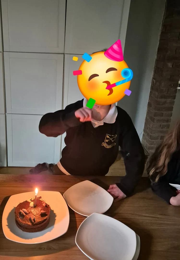 A birthday cake with a single lit candle ready to be blown out